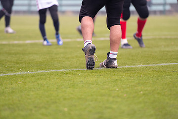 Image showing close up of american football players stretching and warming up