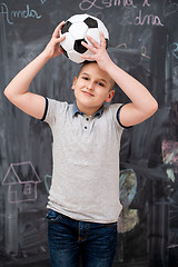 Image showing happy boy holding a soccer ball on his head