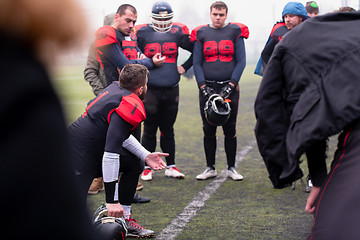 Image showing american football player discussing strategy with his team