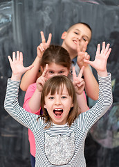 Image showing group of kids standing in front of chalkboard