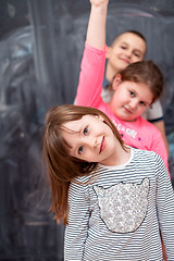 Image showing group of kids standing in front of chalkboard