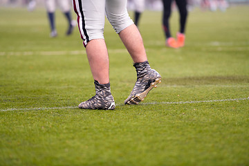 Image showing close up of american football players stretching and warming up