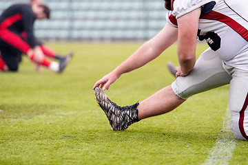 Image showing american football players stretching and warming up