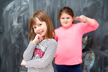 Image showing portrait of little girls in front of chalkboard