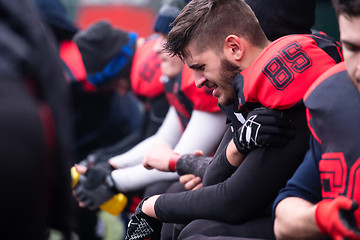 Image showing american football player holding the injured shoulder