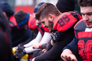 Image showing american football player holding the injured shoulder