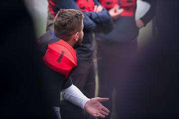 Image showing american football player discussing strategy with his team