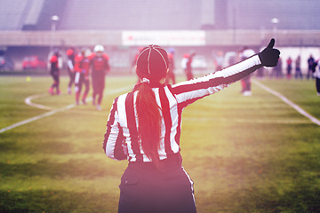 Image showing rear view of female american football referee