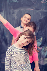 Image showing group of kids standing in front of chalkboard