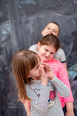 Image showing group of kids standing in front of chalkboard