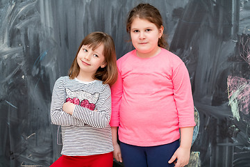 Image showing portrait of little girls in front of chalkboard