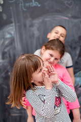 Image showing group of kids standing in front of chalkboard