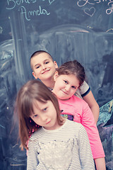 Image showing group of kids standing in front of chalkboard