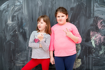 Image showing portrait of little girls in front of chalkboard