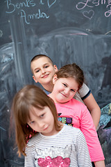 Image showing group of kids standing in front of chalkboard