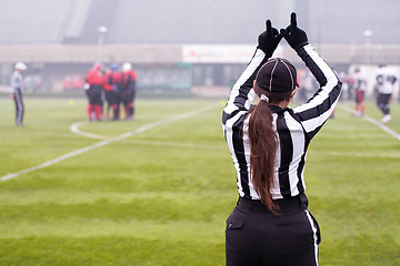 Image showing rear view of female american football referee