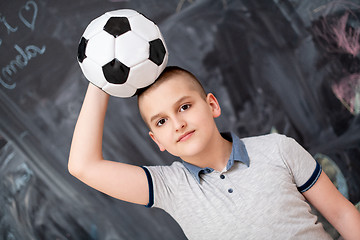 Image showing happy boy holding a soccer ball on his head