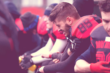 Image showing american football player holding the injured shoulder