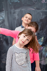 Image showing group of kids standing in front of chalkboard