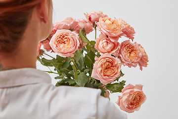 Image showing Bouquet of beautiful roses in the hands of a girl