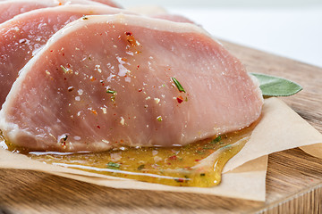 Image showing raw pork escalope with sause made of honey and herbs