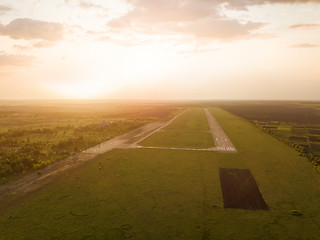 Image showing Aerial view from the drone, a bird\'s eye view of abstract geometric forms of abandoned runway, forests and fields in the summer evening at sunset.