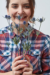 Image showing Young girl with flowers eryngium