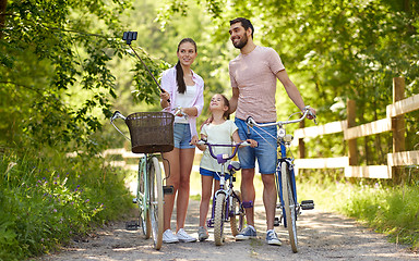 Image showing happy family with bicycles taking selfie in summer