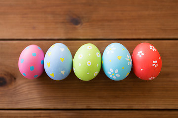 Image showing row of colored easter eggs on wooden table