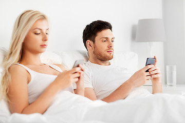 Image showing couple with smartphones in bed