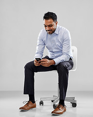 Image showing smiling indian businessman sitting on office chair