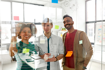 Image showing happy creative team at office glass board