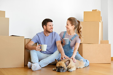 Image showing happy couple with boxes and dog moving to new home