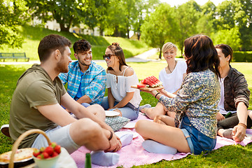 Image showing happy friends eating watermelon at summer picnic