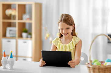 Image showing happy girl with tablet pc and easter eggs at home