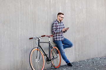 Image showing hipster man in earphones with smartphone and bike