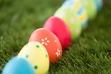 Image showing row of colored easter eggs on artificial grass