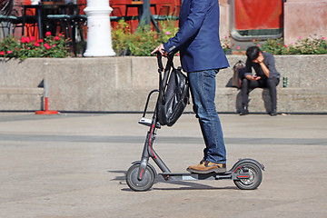 Image showing Man riding a kick scooter at the city square