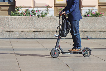 Image showing Man riding a kick scooter at the city square