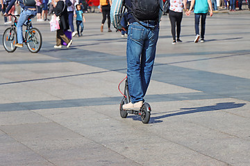 Image showing Man riding a kick scooter at the city square