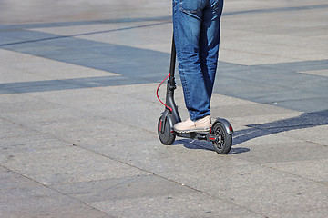 Image showing Man riding a kick scooter at the city square