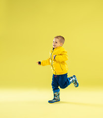 Image showing A full length portrait of a bright fashionable boy in a raincoat