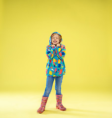 Image showing A full length portrait of a bright fashionable girl in a raincoat