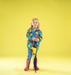 Image showing A full length portrait of a bright fashionable girl in a raincoat