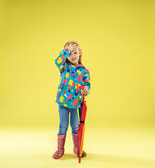 Image showing A full length portrait of a bright fashionable girl in a raincoat