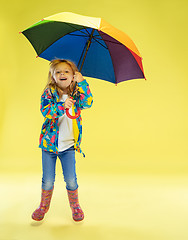 Image showing A full length portrait of a bright fashionable girl in a raincoat