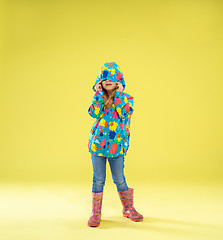 Image showing A full length portrait of a bright fashionable girl in a raincoat