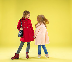 Image showing A full length portrait of a bright fashionable girls in a raincoat