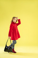 Image showing A full length portrait of a bright fashionable girl in a raincoat