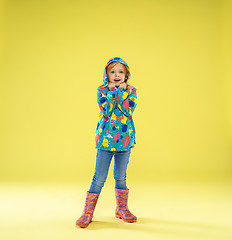 Image showing A full length portrait of a bright fashionable girl in a raincoat